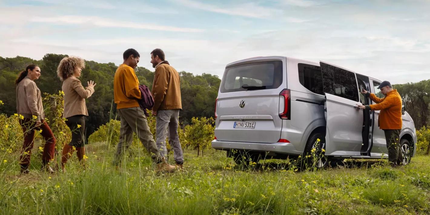 Volkswagen bedrijfsvoertuigen caravelle in het bos met familie